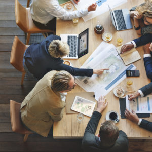 Business leaders discuss strategy around a meeting table.